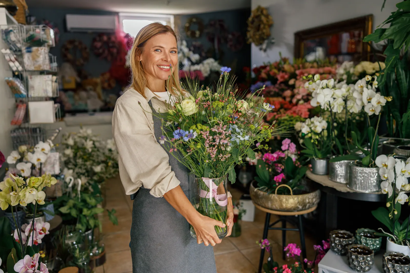 A florist holding a fresh bouquet in her shop